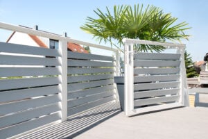 alubalkon modell villach mit waagrechten latten aus aluminium und einer balkontuer