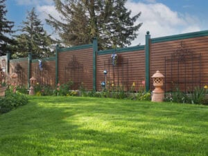 Ein Zaun aus Aluminium in Holzoptik in einem schönen Garten im Frühling
