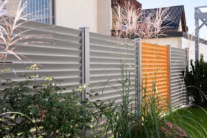 aluzaun landeck in graualuminium und holzstruktur im garten
