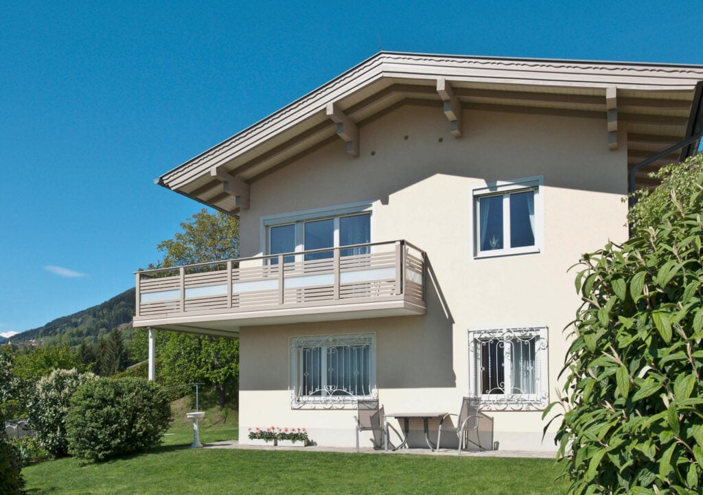 Zarte Hausfassade mit Alu-Anbaubalkon