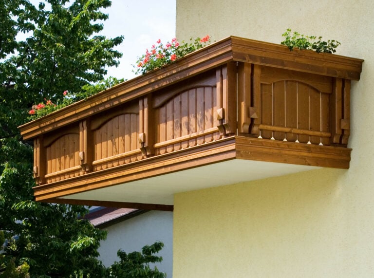 Gelbe Hausfassade mit Holz Classic Semmering Balkongeländer