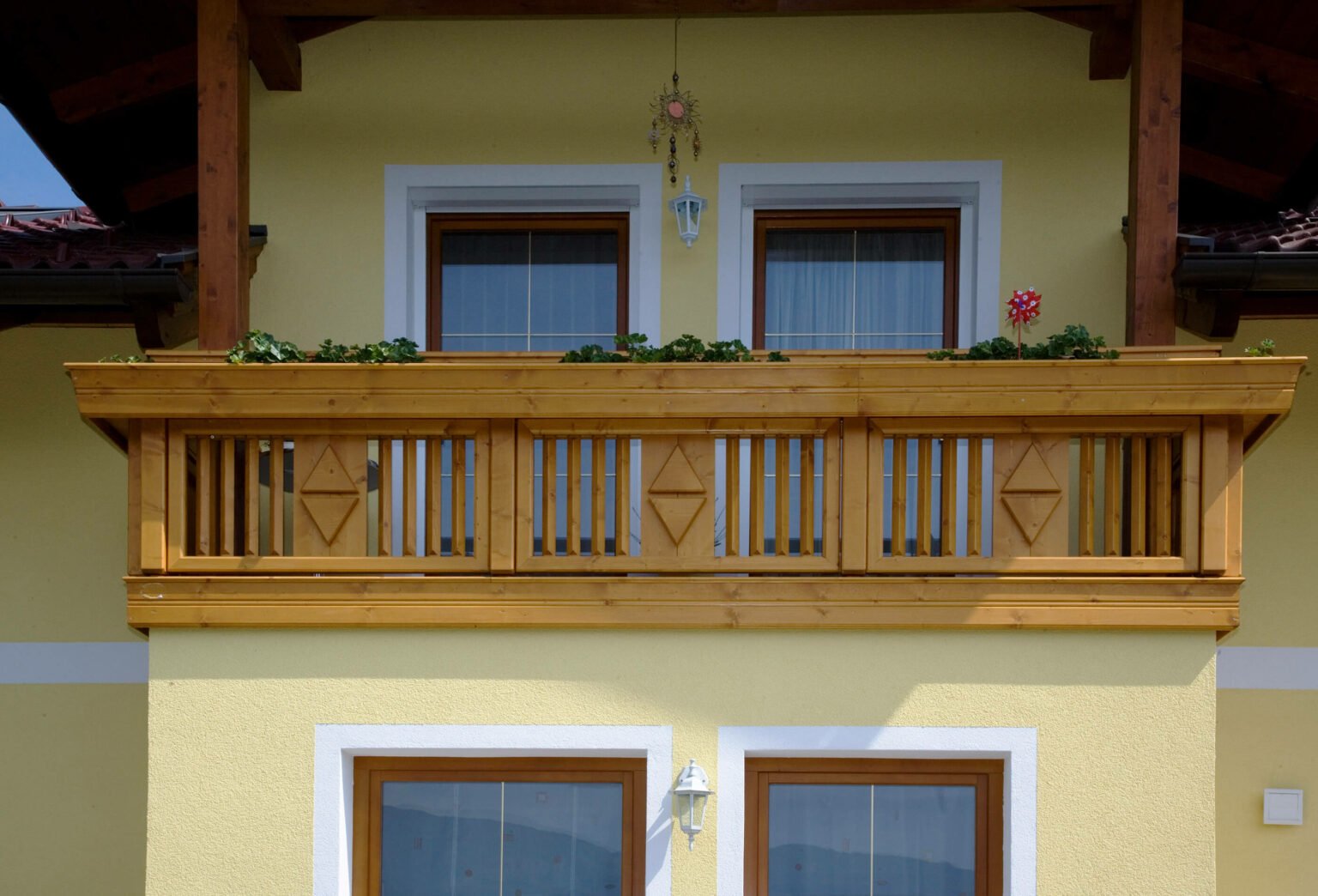 Liebevoll dekorierter Balkon mit Holz Classic Spielfeld Balkongeländer