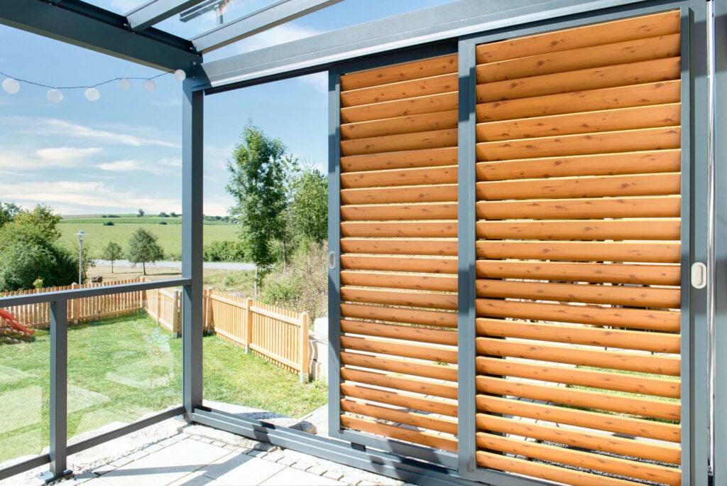 Sommergarten mit schräggestellten Alu-Lamellen in Holzoptik