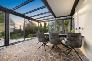 sommergarten mit offenen schiebeelementen und gartengarnitur