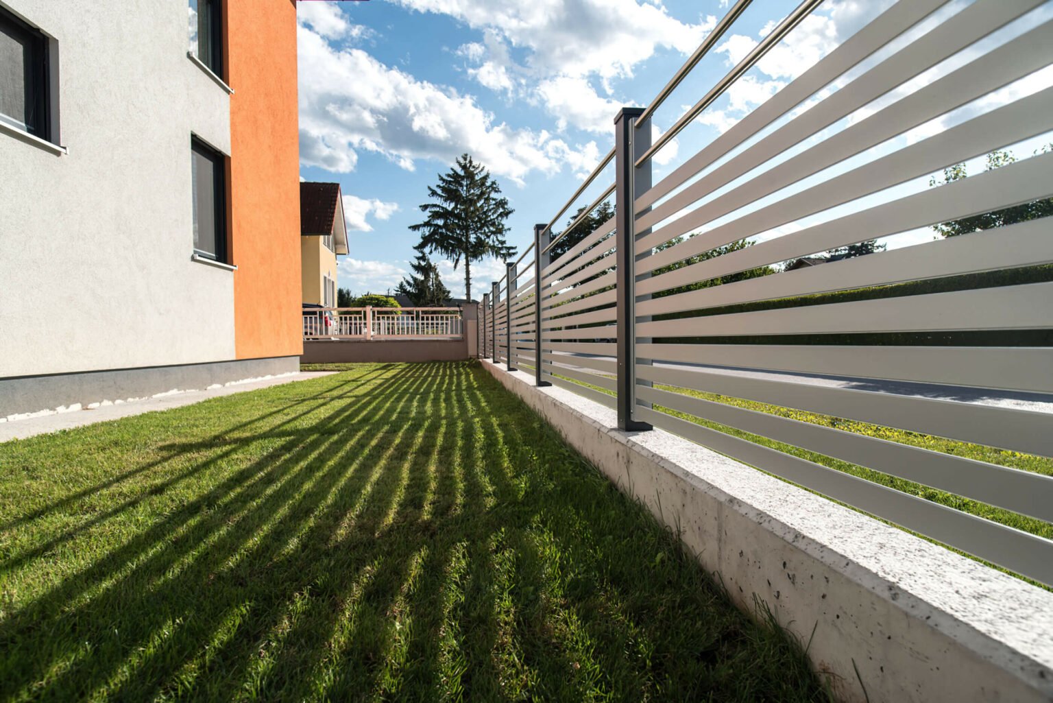 Hausfassade mit Orange und Grau mit Aluzaun Barcelona