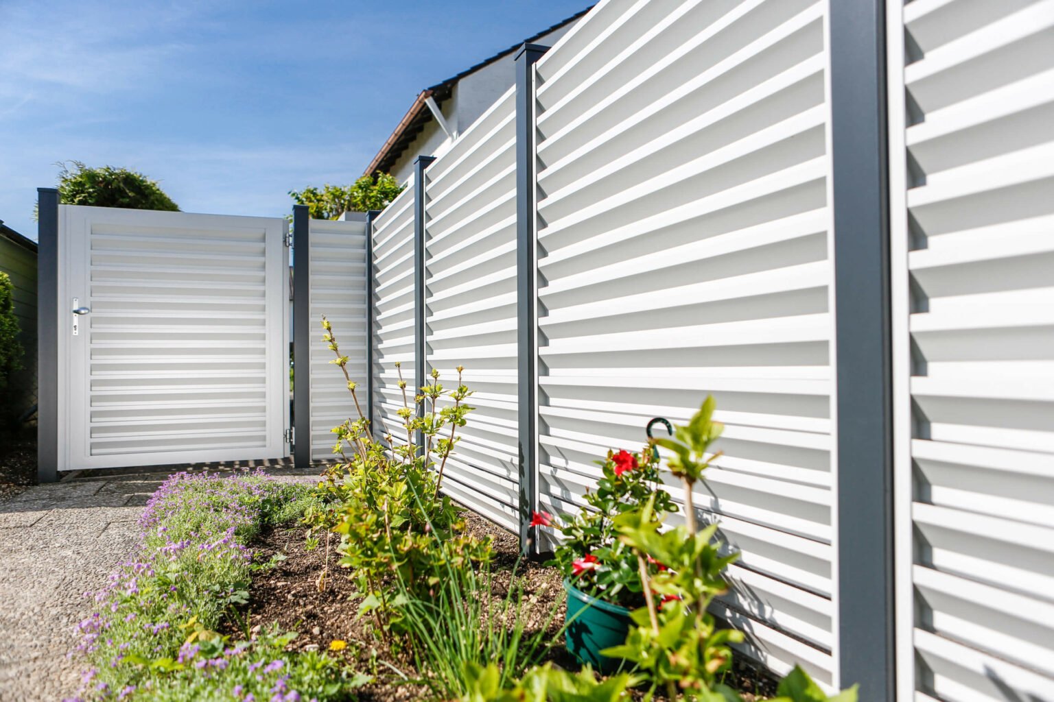 Gepflegte Blumenrabatte mit Alu Zaun Grado