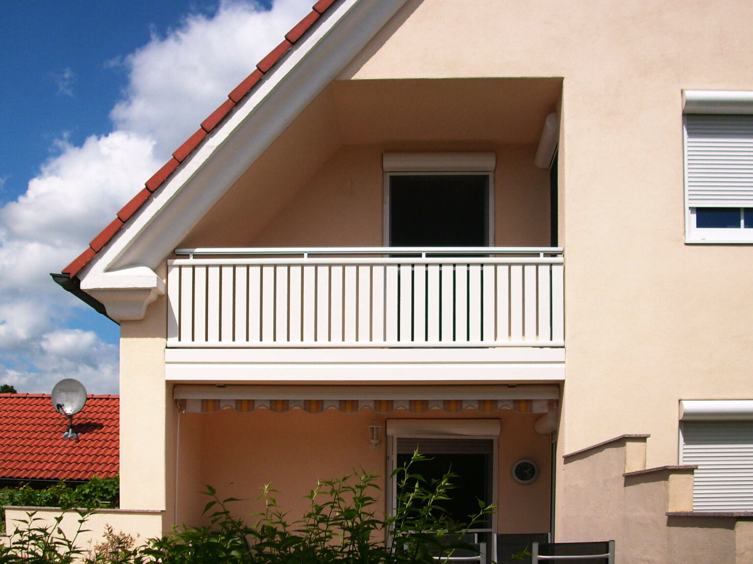 Rosa Einfamilienhaus mit Ziegeldach mit Alu Select Balkongeländer