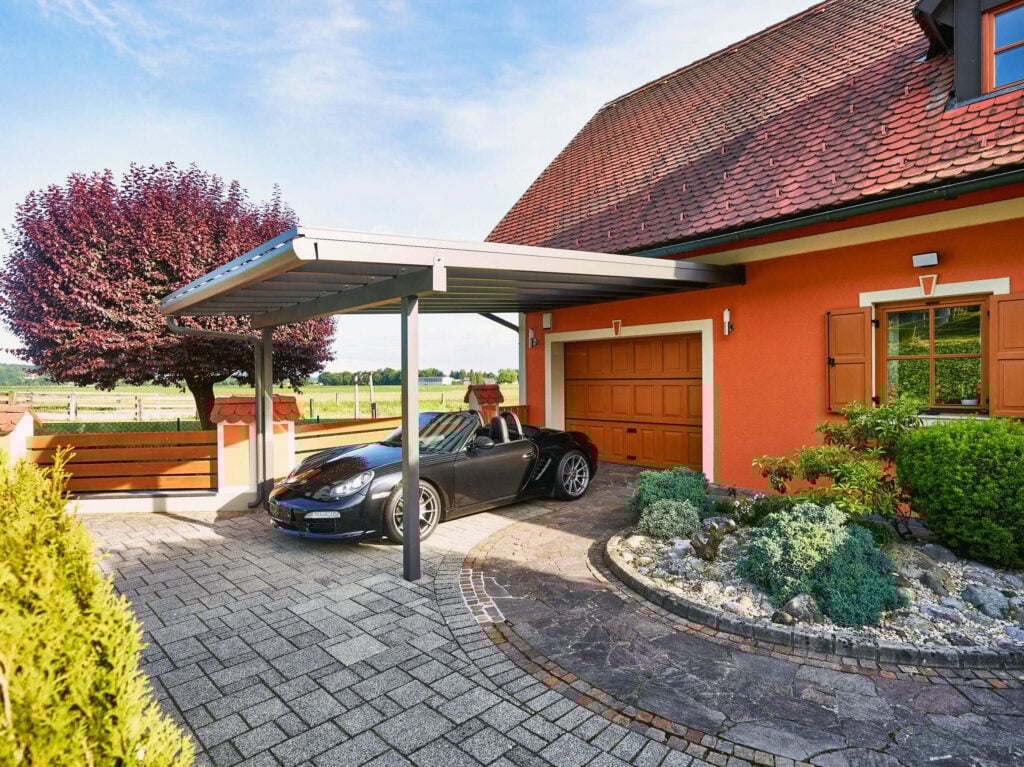 Oranges Wohnhaus mit schwarzem Porsche unter Alu-Carport